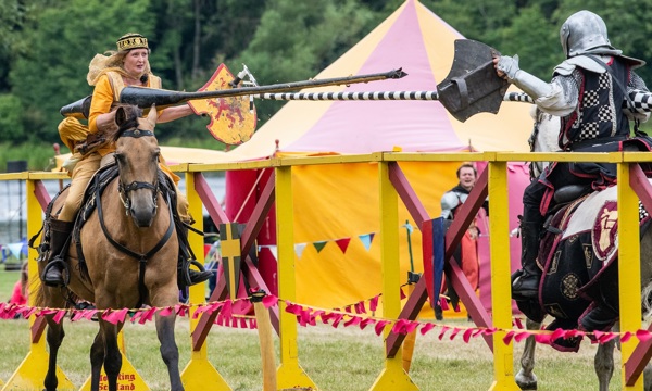 A woman in Renaissance clothing jousts with a knight