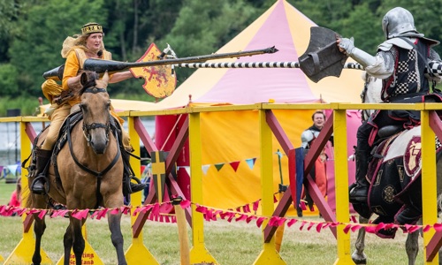 A woman in Renaissance clothing jousts with a knight