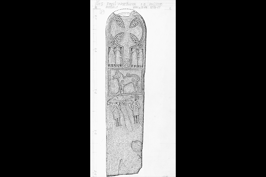 A tall, thin standing stone etched with many carvings
