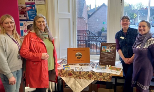 A photo of the the book launch of ‘The Chronicles of Angus - Life through a Lens’ at Angus Alive Kirriemuir Library. Four people smiling at the camera are in the photo presenting the book.