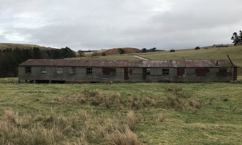 A long timber and corrugated iron accomodation hut at the site of a former military camp