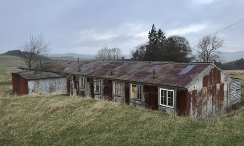 A corrugated iron and timber accomodation hut on the site of a former military camp