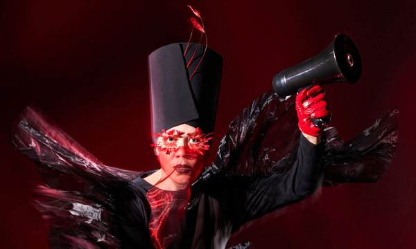 A woman in a dramatic black costume with red gloves and accessories