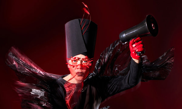 A woman in a dramatic black costume with red gloves and accessories