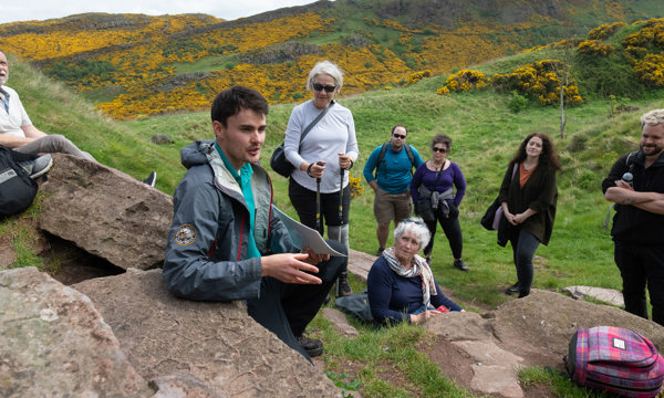 A ranger leading a group of walkers at Holyrood Park.