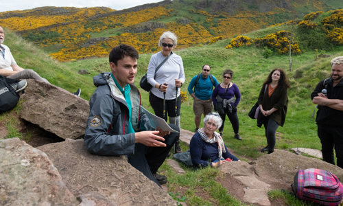 A ranger leading a group of walkers at Holyrood Park.