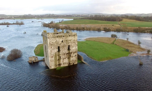 A castle on an island surrounded by water and marshland 