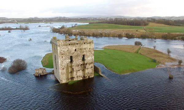 A castle on an island surrounded by water and marshland 