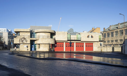 Exterior view of Tollcross Fire Station, an impressive building with large red doors
