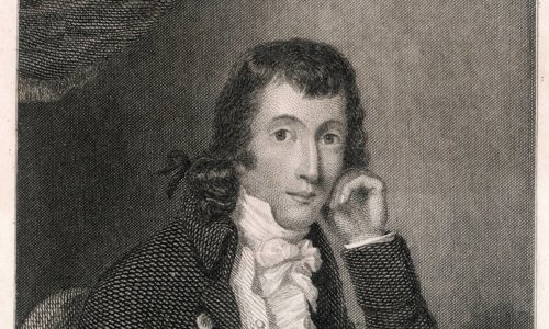 Black and white drawing of a person seated at a table writing a letter. They are using a quill pen and are looking at the camera, with their other hand resting against their face. They are wearing a jacket with many buttons and a frilled white shirt.