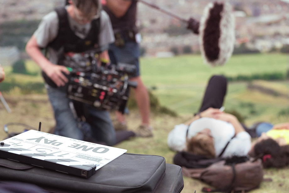 Close up of camera crew filming actors Leo Woodall & Ambika Mod lying on grass at Arthur's Seat for the Netflix series One Day