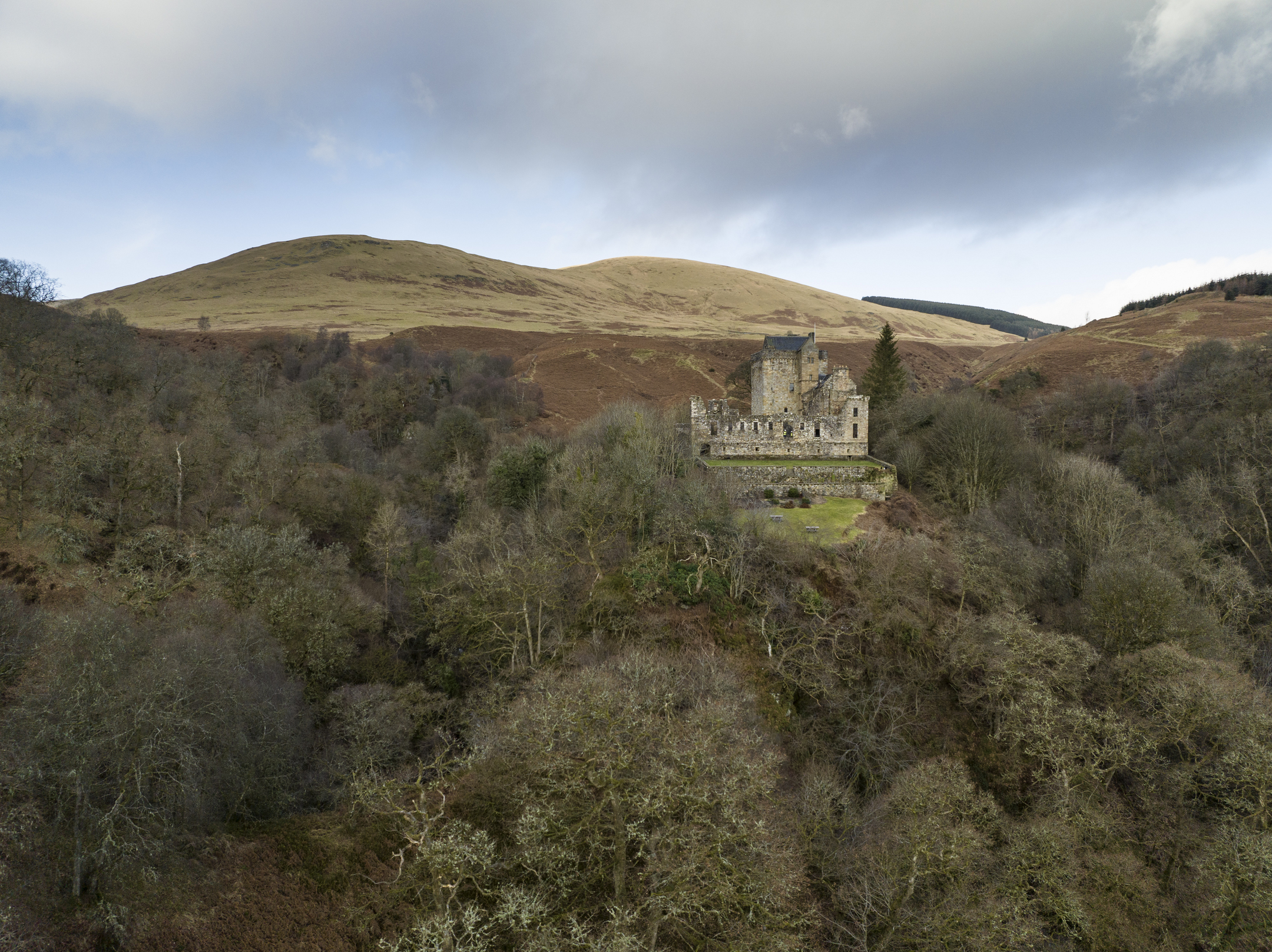 Castle Campbell  in the distance between the Dollar Glen and green trees. 