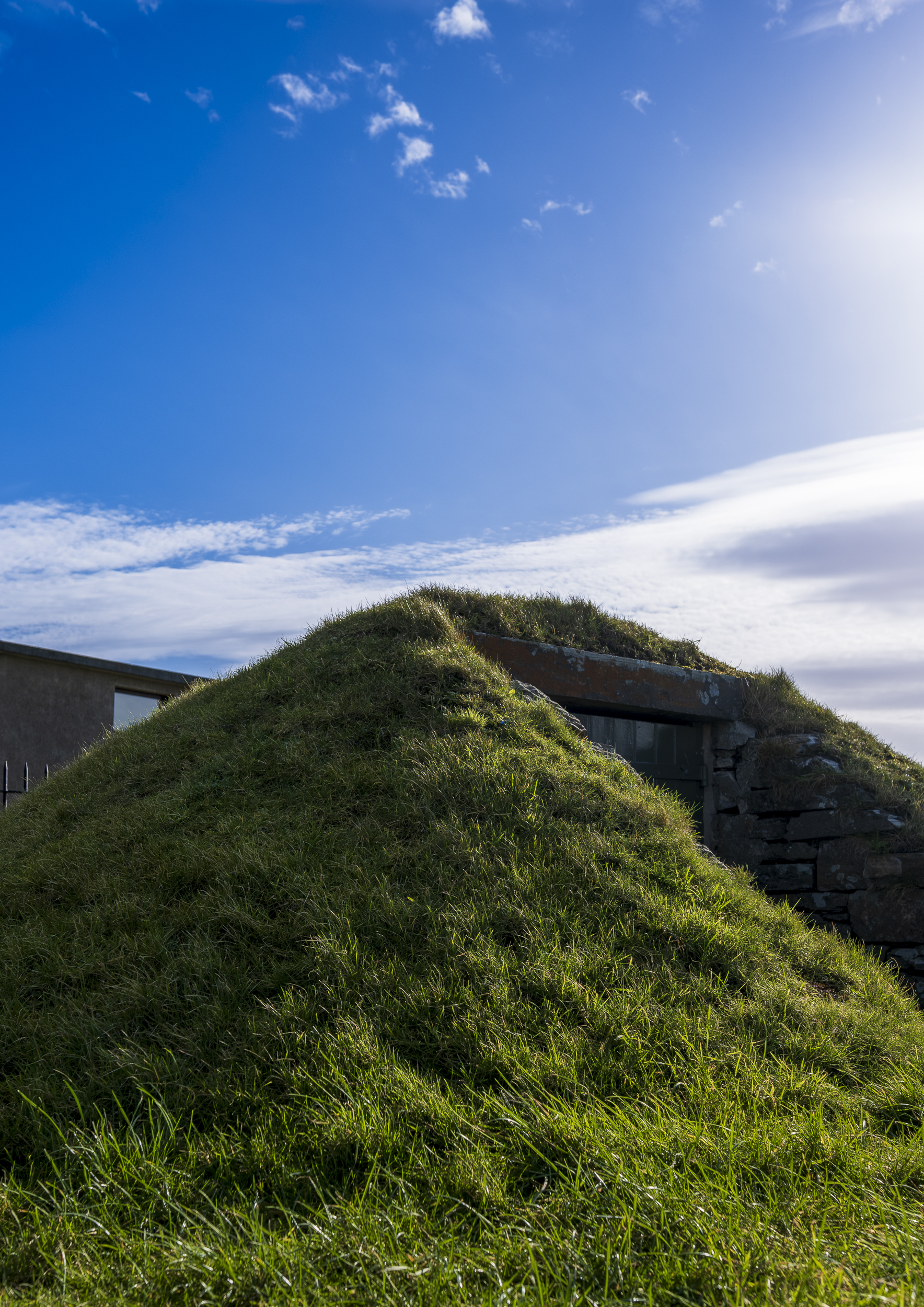 A tall, grassy mound with an area cut out in the middle to form an entrance