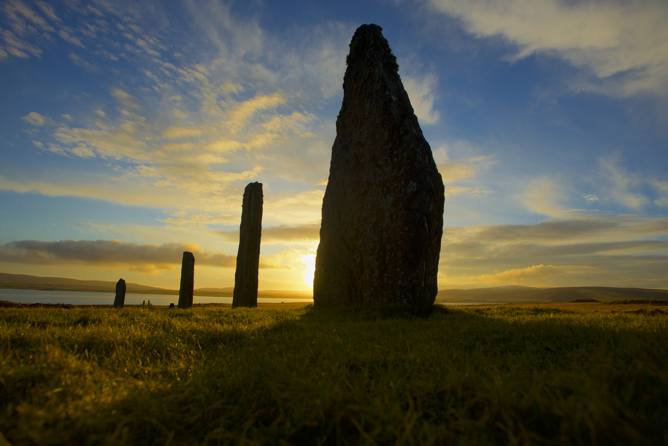 Four stones from the Ring of Brodgar with the sunset behind them 