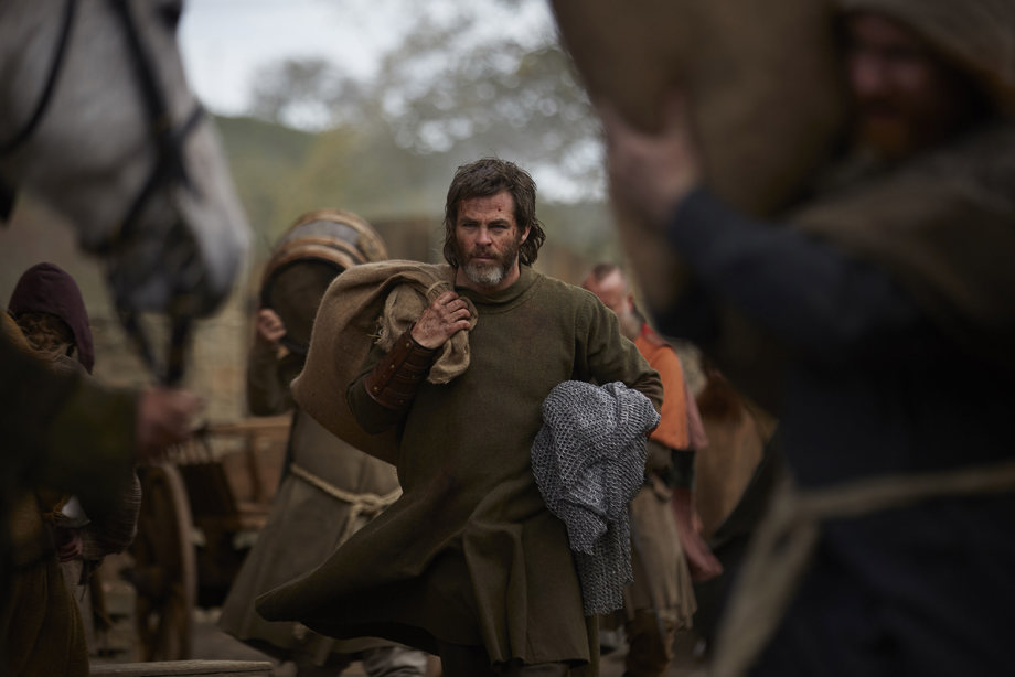 Chris Pine as Robert the Bruce, carrying chainmail and a hessian sack
