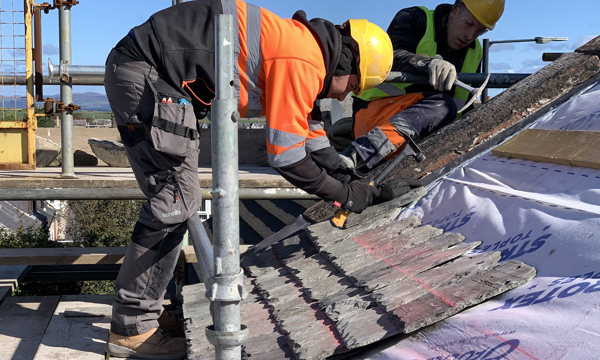 A slater working on a roof at 9 High St in Whithorn