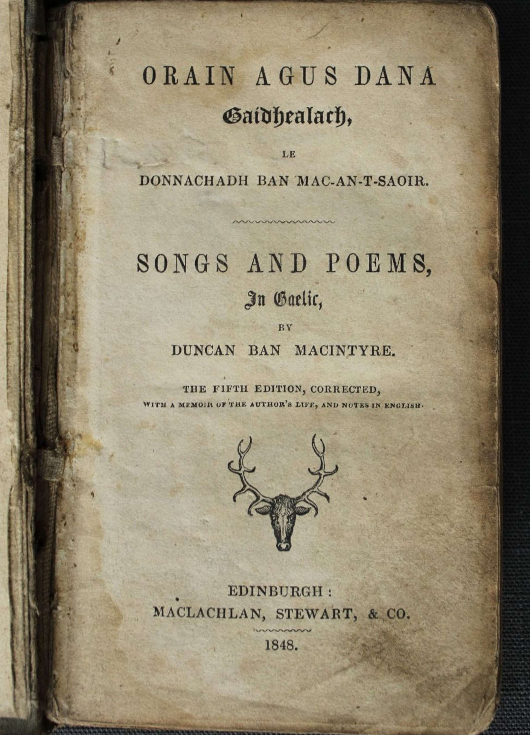 Front matter page of Duncan Ban MacIntyre's book of 'Songs and Poems in Gaelic'. The paper, which has been scanned, is old and browned, and features a picture of an deer's head and antlers.