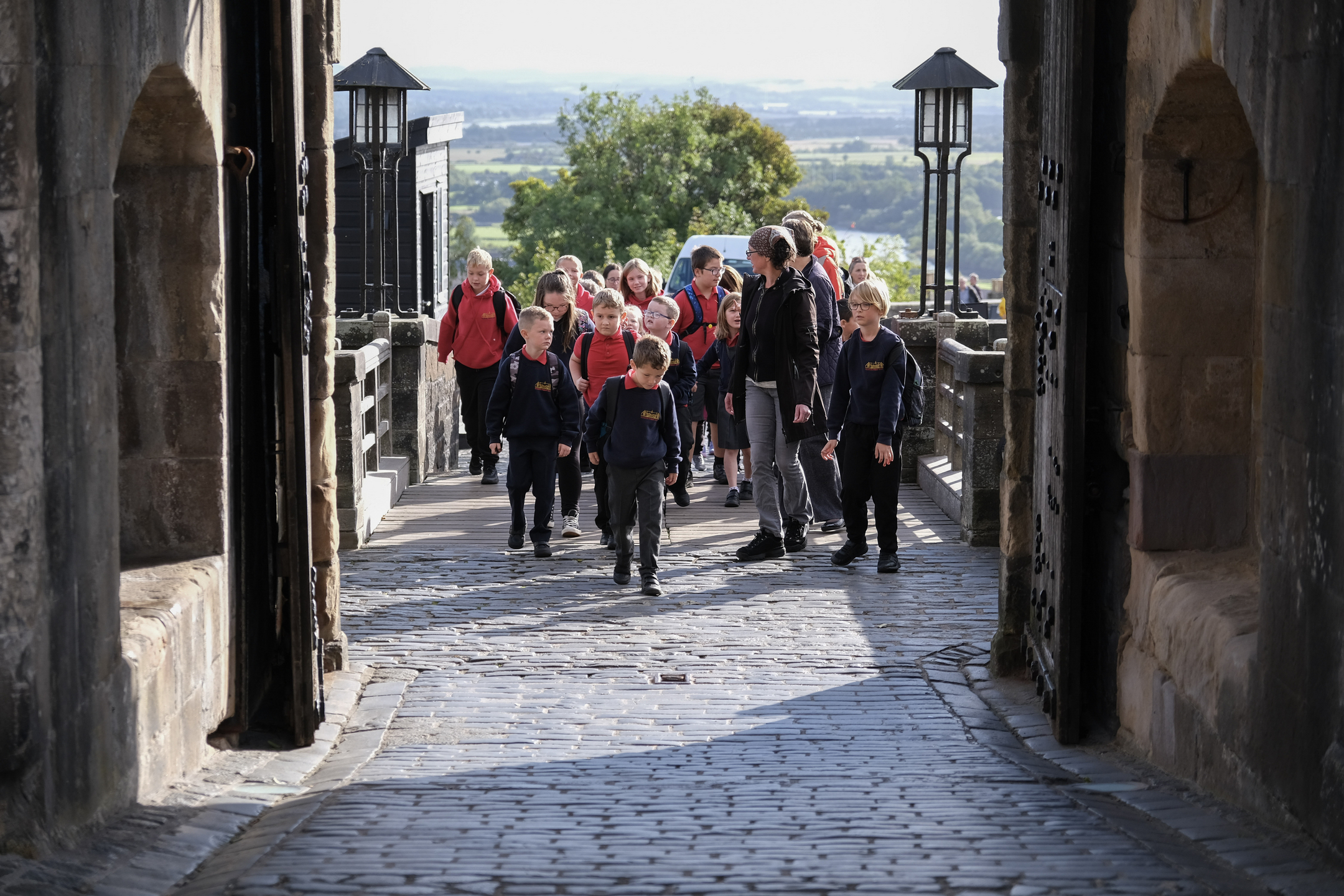 Group of school pupils coming through main entrance way of castle