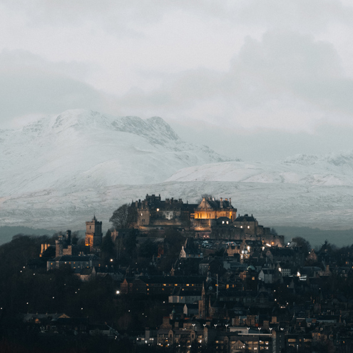 Stirling Castle from a distance at dusk and snowy hills in the background by @alljustpaul on Instagram