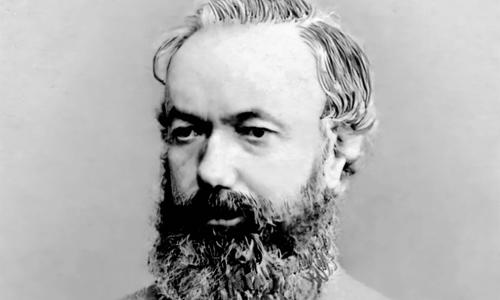 black and white portrait photograph of a person. They are wearing a suit with a bow tie, and they have a long, full beard.