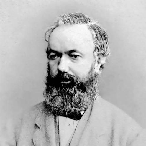 black and white portrait photograph of a person. They are wearing a suit with a bow tie, and they have a long, full beard.