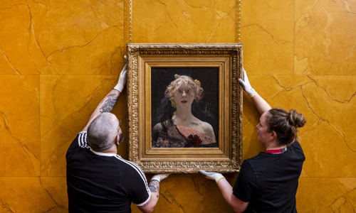 Two members of staff hang up the photo of 'Berenice'