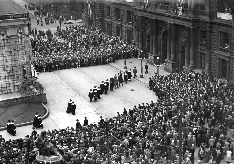 Black and white photograph of a large crowd outside the City Chambers watching the Victory in Europe ceremony proceedings.