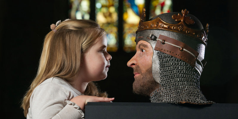 A girl in Dunfermline Abbey looking at a 3D model of Robert the Bruce