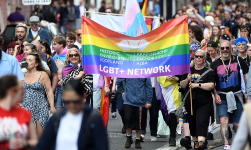 Members of the Historic Environment Scotland staff network with a pride banner