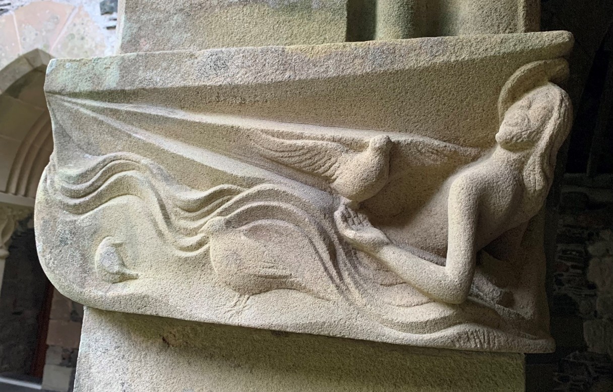 Sculpture of a figure with doves in white stone.
