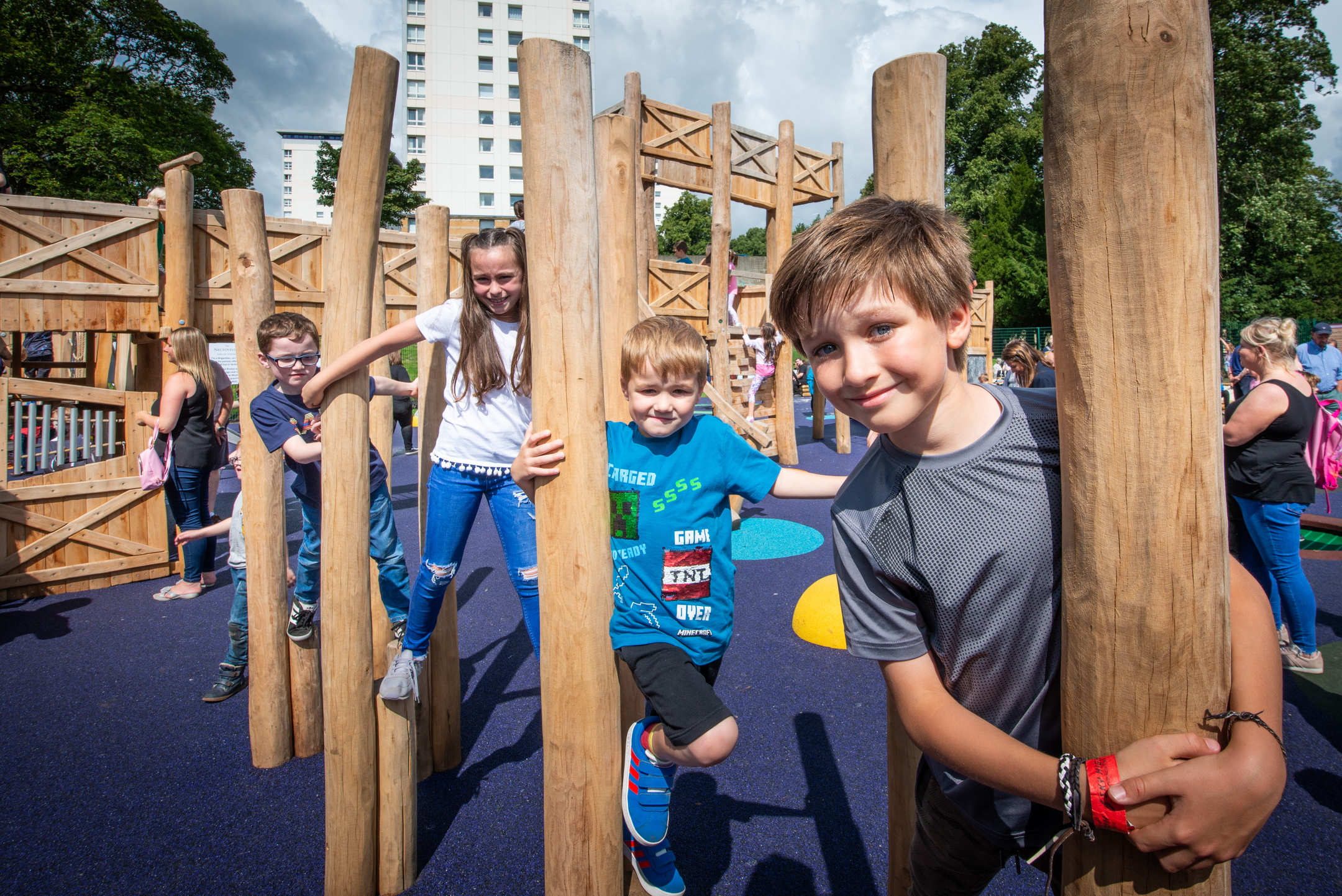 Children climbing on wooden obstacles at a roman themed play park 