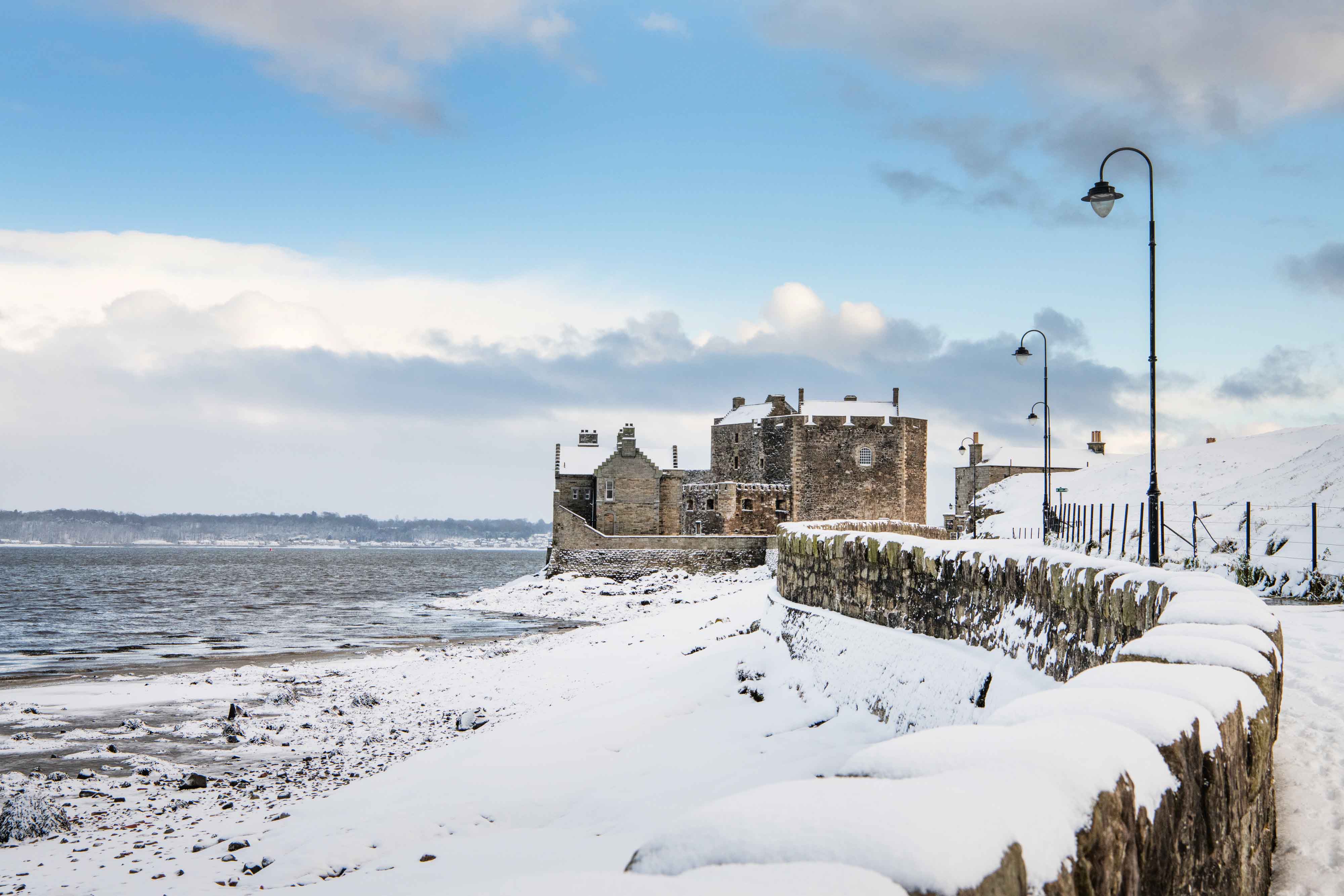 The winding road leading up to Blackness Castle, with the castle, wall and beach covered in snow