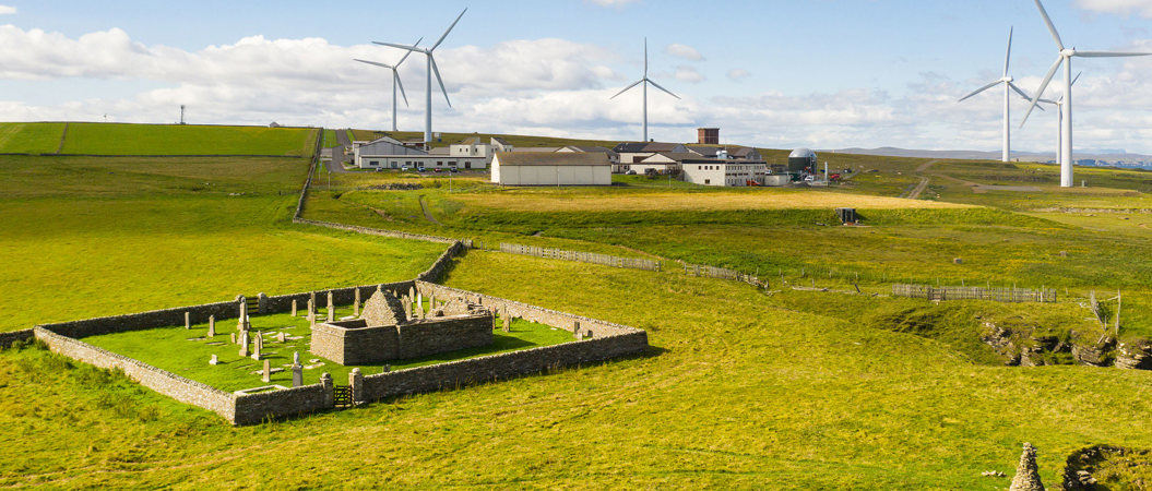Aerial view of St Mary's Chapel, Cross Kirk, Thurso, with wind turbines in the background