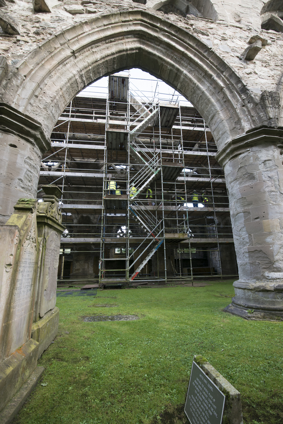 Scaffolding fills a large arched opening inside a ruined stone building