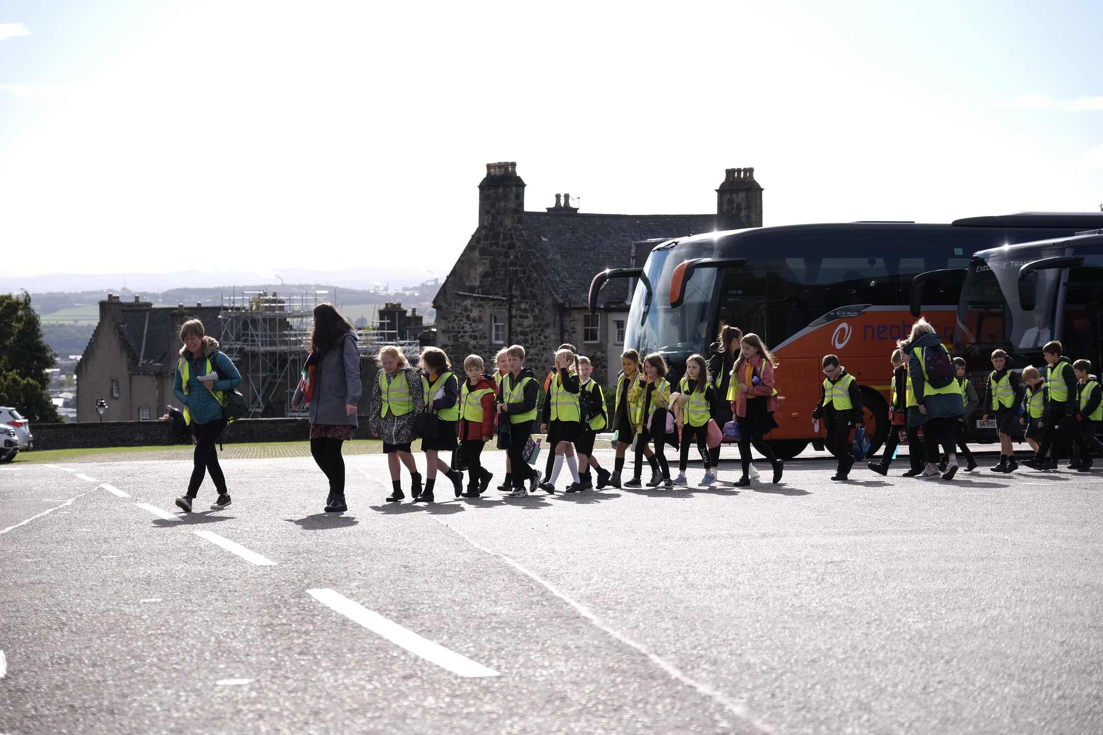 School pupils walking away from a bus in a line