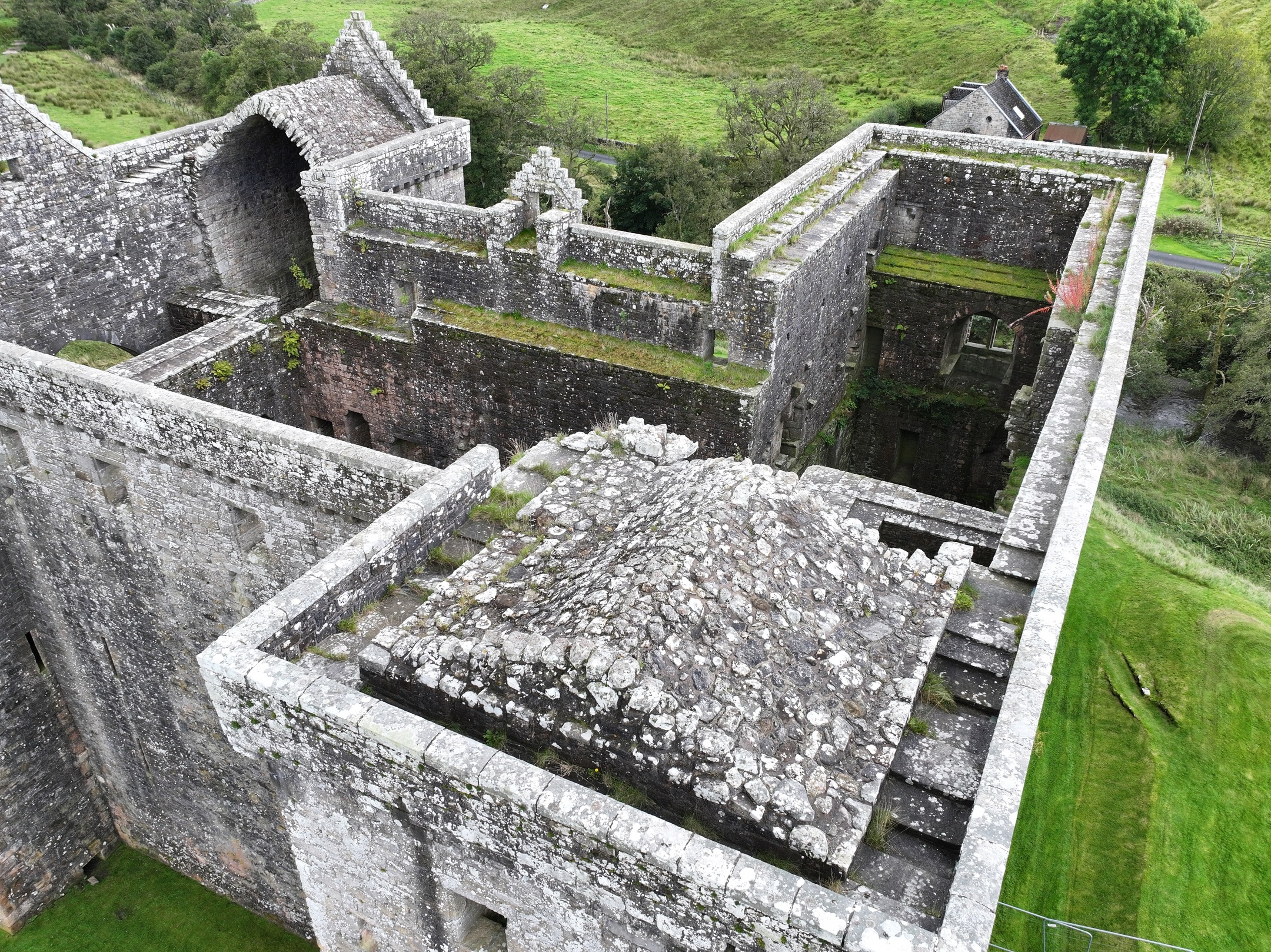 Aerial view looking down into the interior ruins and walls of Hermitage Castle.