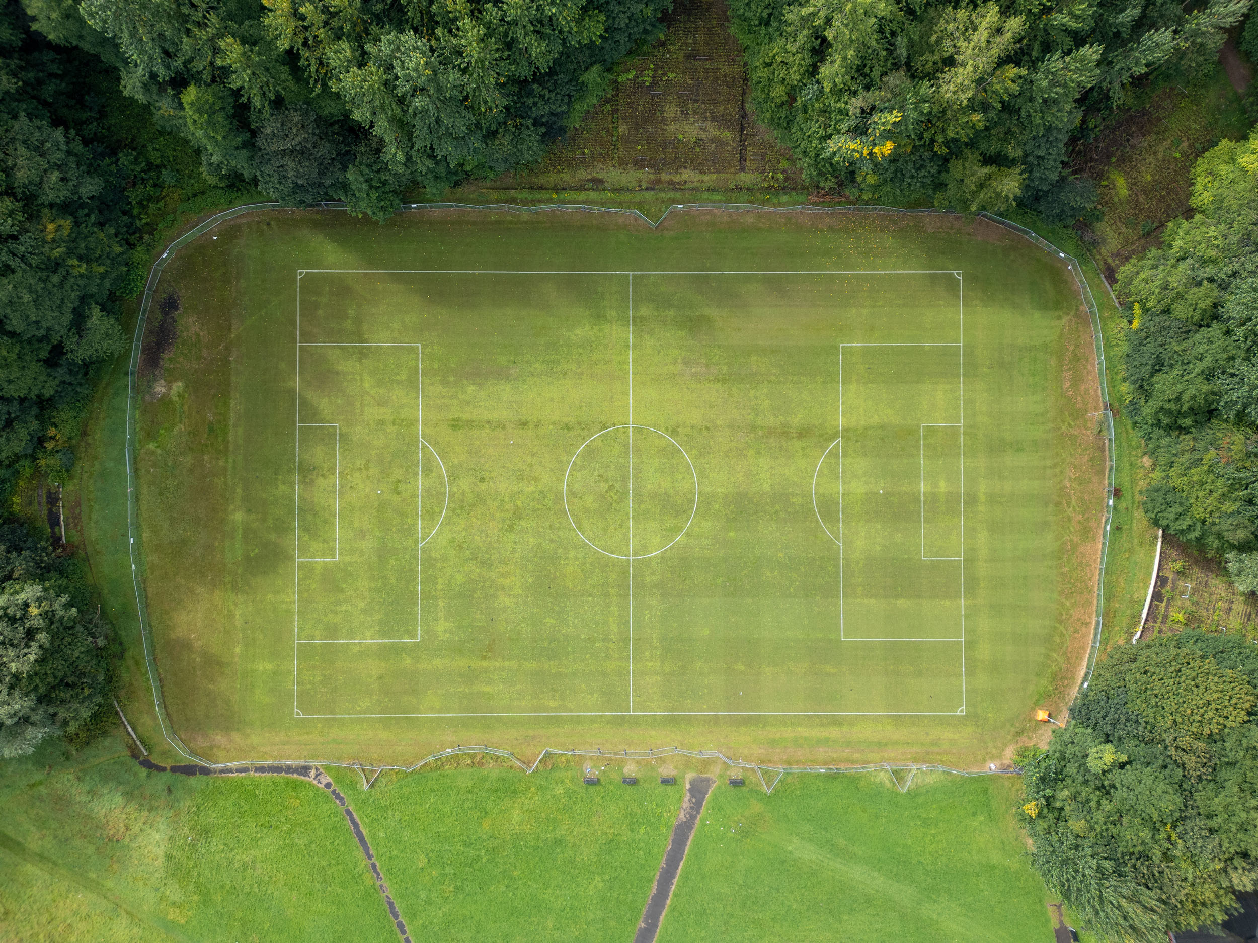 Aerial view directly above Cathkin Park football stadium dating back to 1884, surrounded by trees.