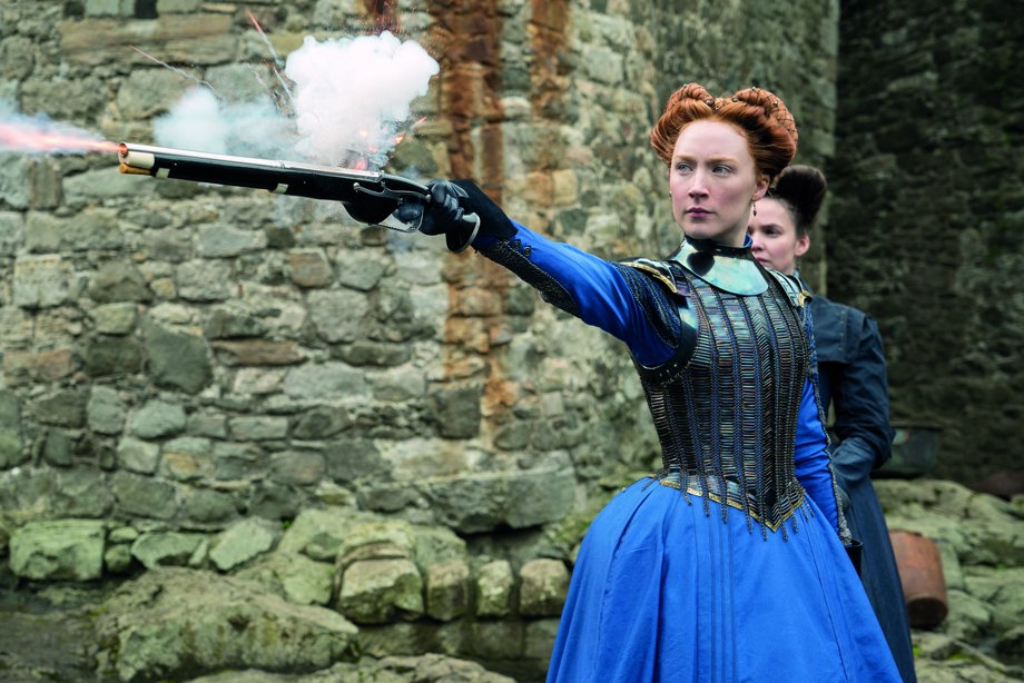 Saoirse Ronan who plays Mary Stuart firing a gun and Eileen O’Higgins in the background who plays her attendant, Mary Beaton