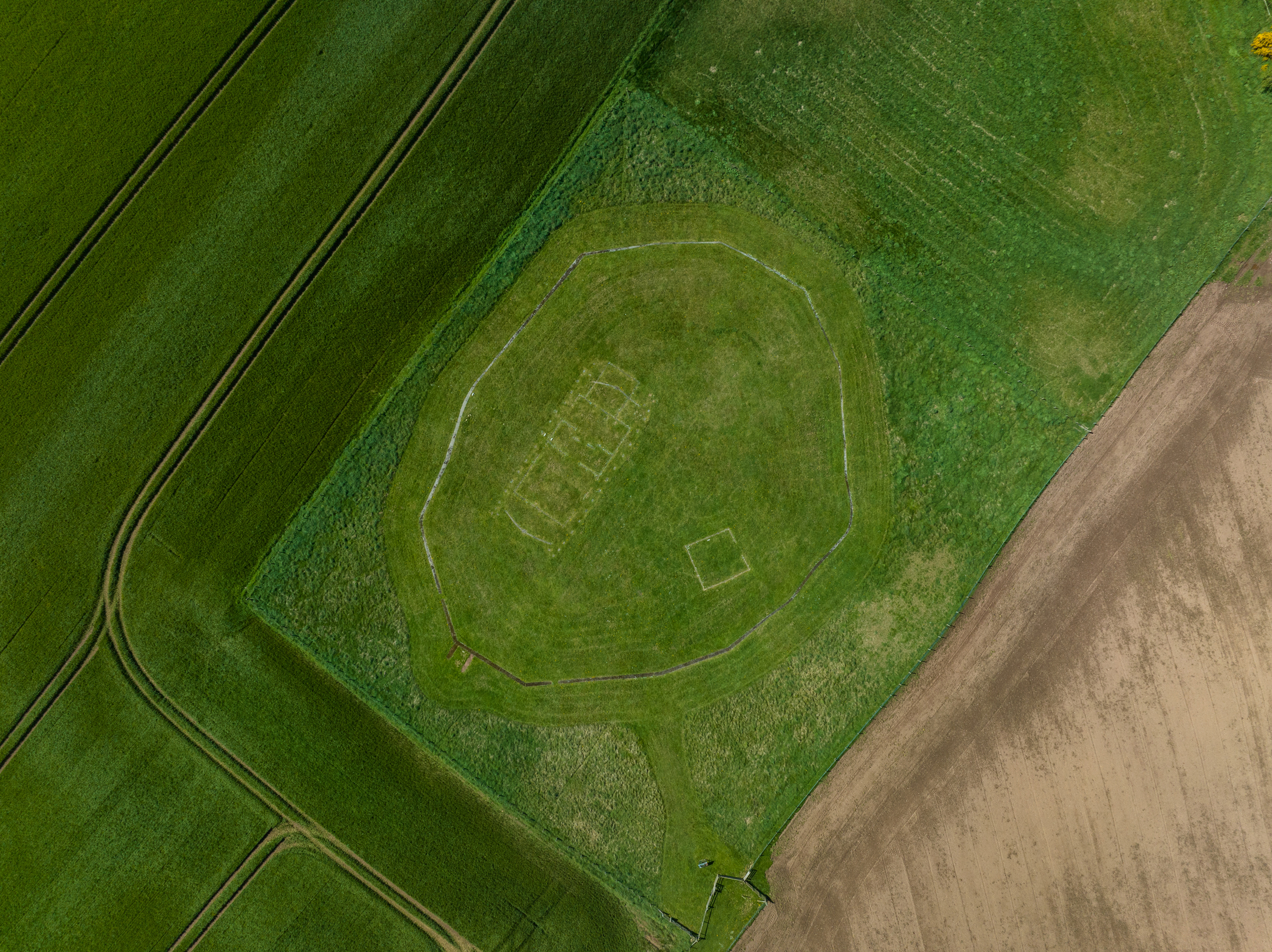 Aerial view from directly above site of previous settlement, showing where a building was and a perimeter fence