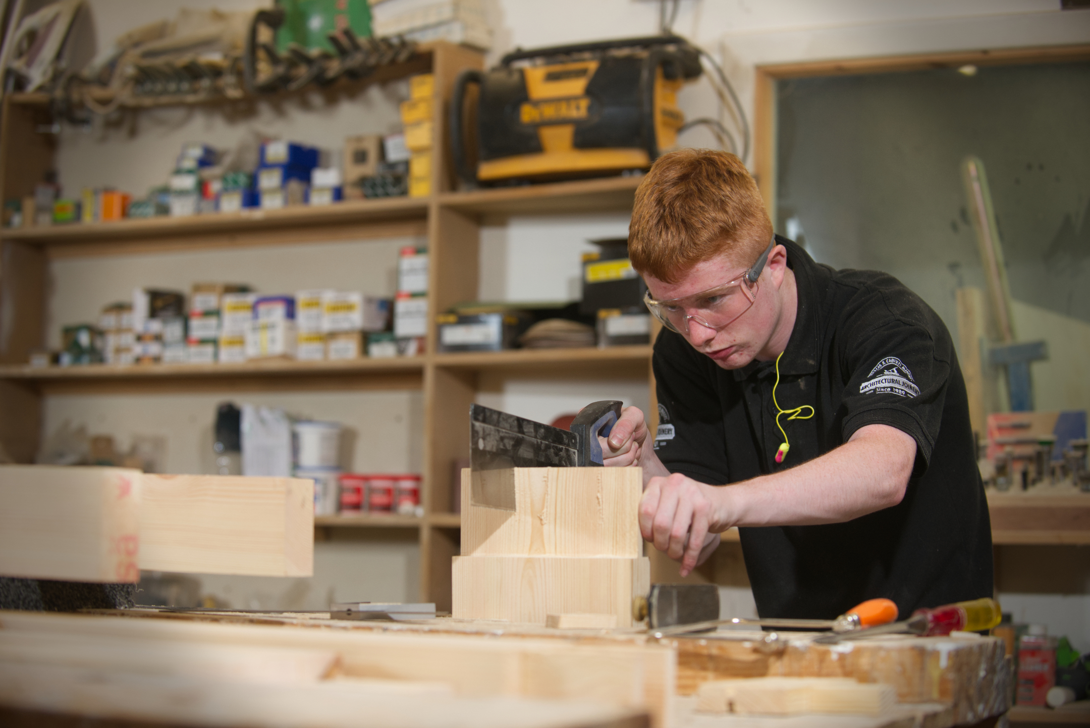 Apprentice joiner in workshop working on wood