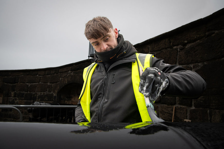A man wearing a high vis jacket and painting a cannon