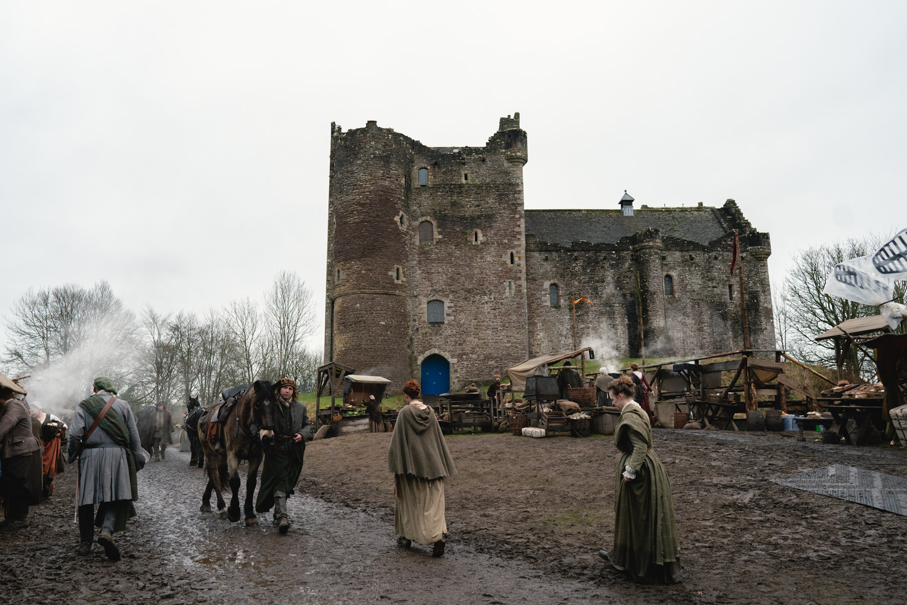 Doune Castle in use as a film set. Extras and props have recreated a bustling castle courtyard in the shadow of the imposing walls.