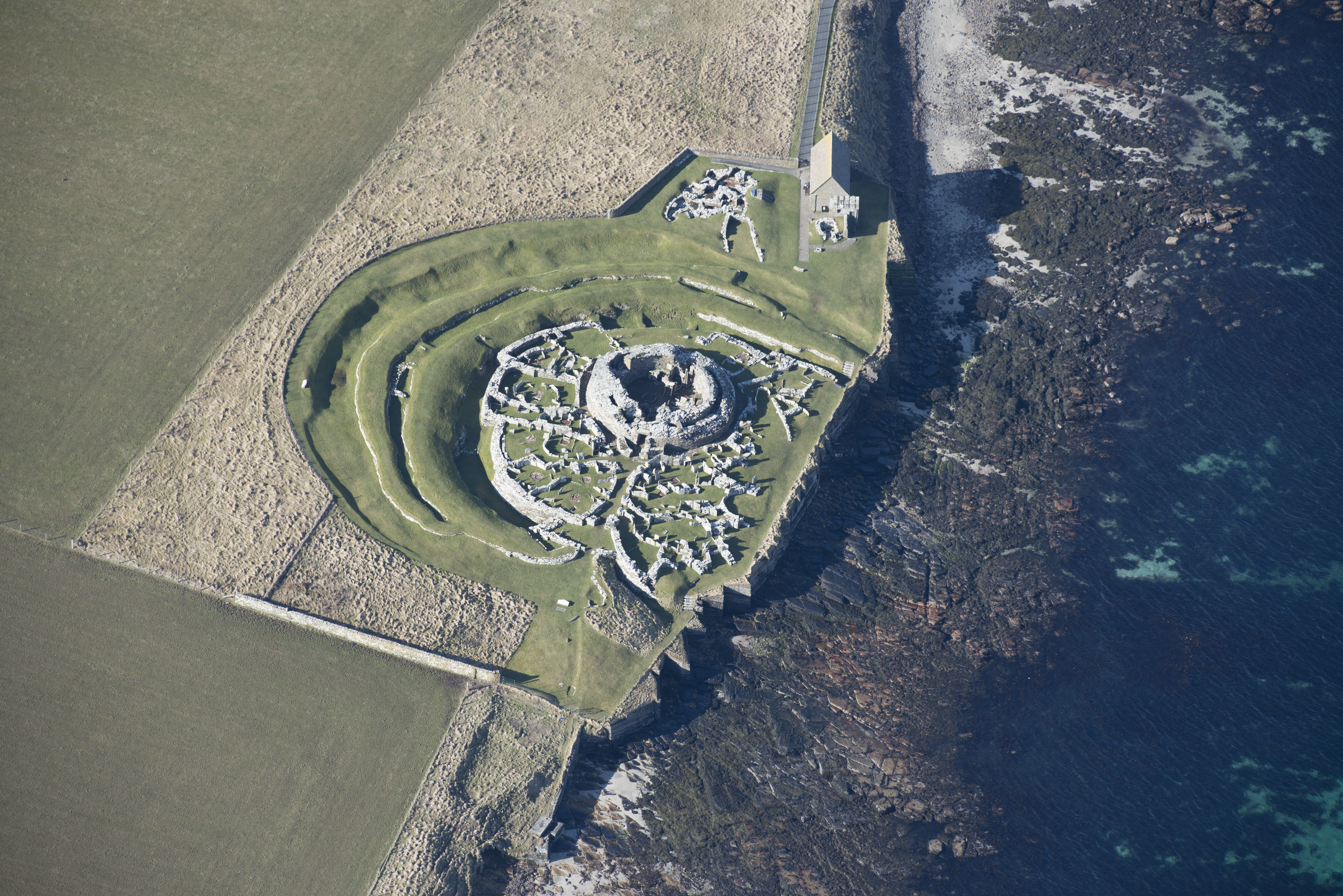 Aerial view of a broch by the coastline