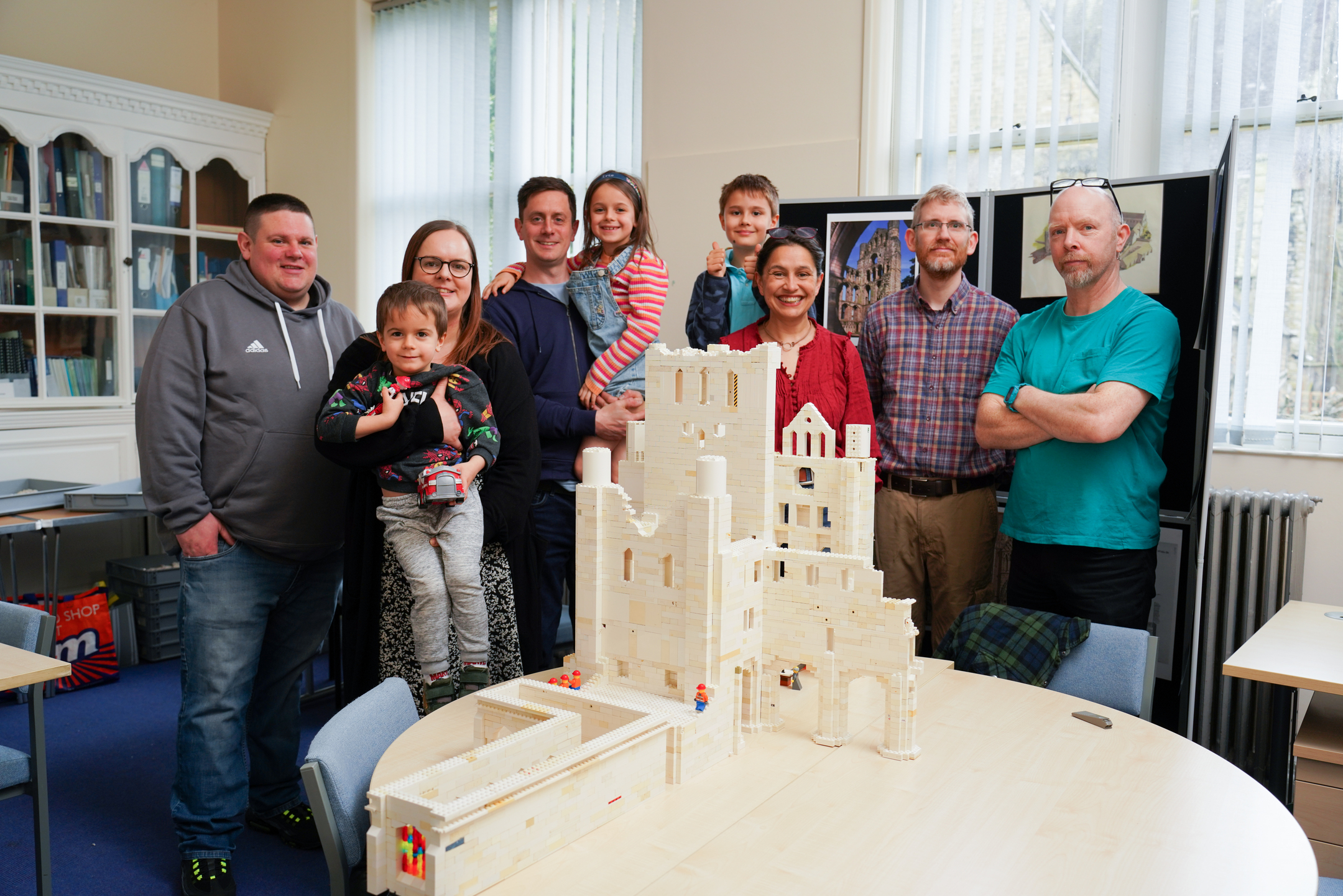 A group of Lego builders pose proudly with their creation - an intricate Lego model of Kelso Abbey.
