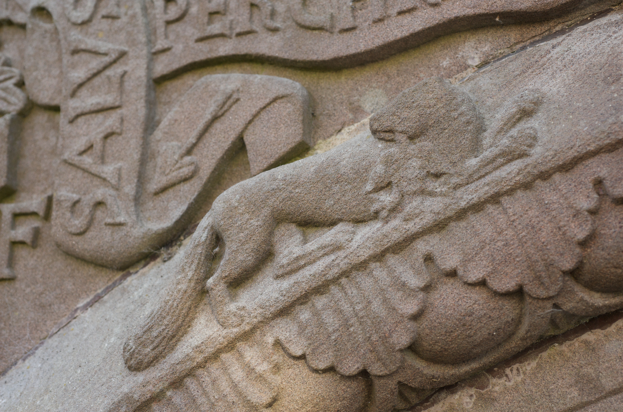 An ornately carved animal, possibly a lion, on a stone tomb