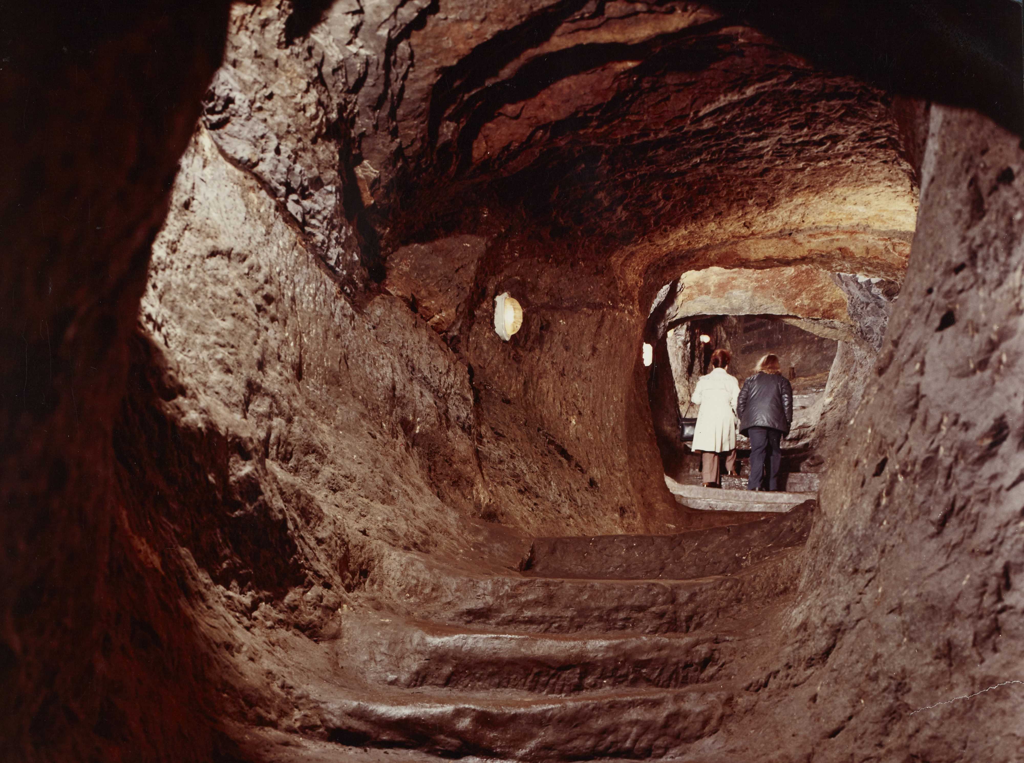 View inside the tunnels at St Andrews Castle. Two people are walking away in the distance