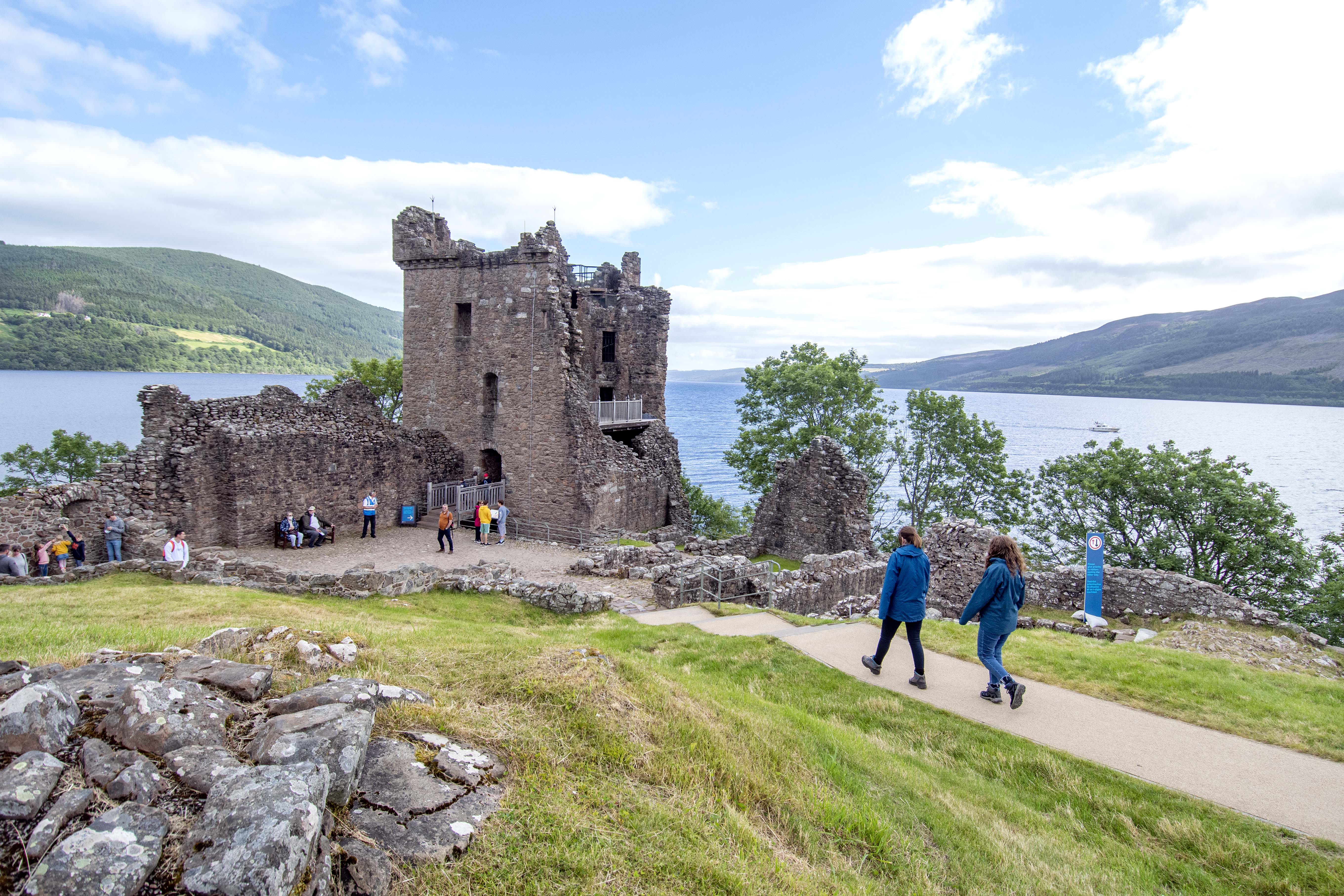 Visitors to a castle walk along a path to a tower, which they will be able to climb