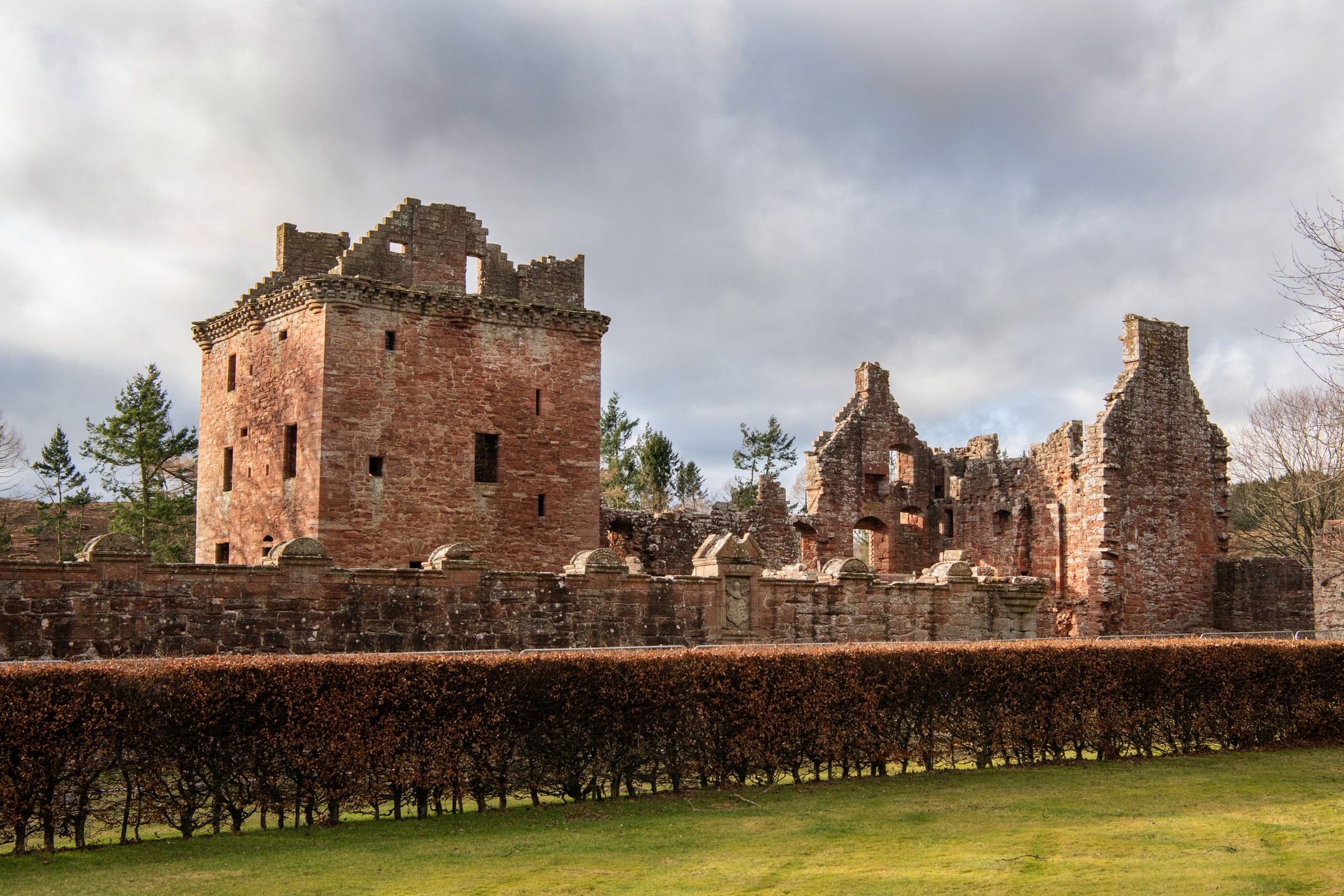 Red sandstone ruins of a castle. The imposing central tower house is in a well-preserved condition, considering its age. 