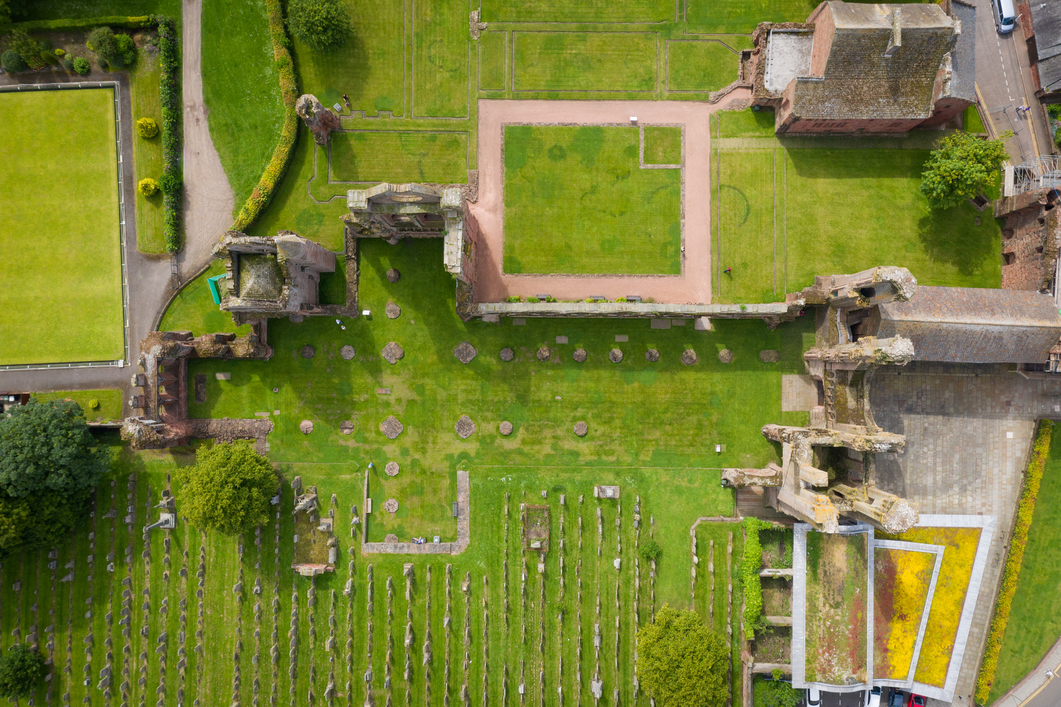 Aerial view of abbey ruin with one side in good tact and the other side gone