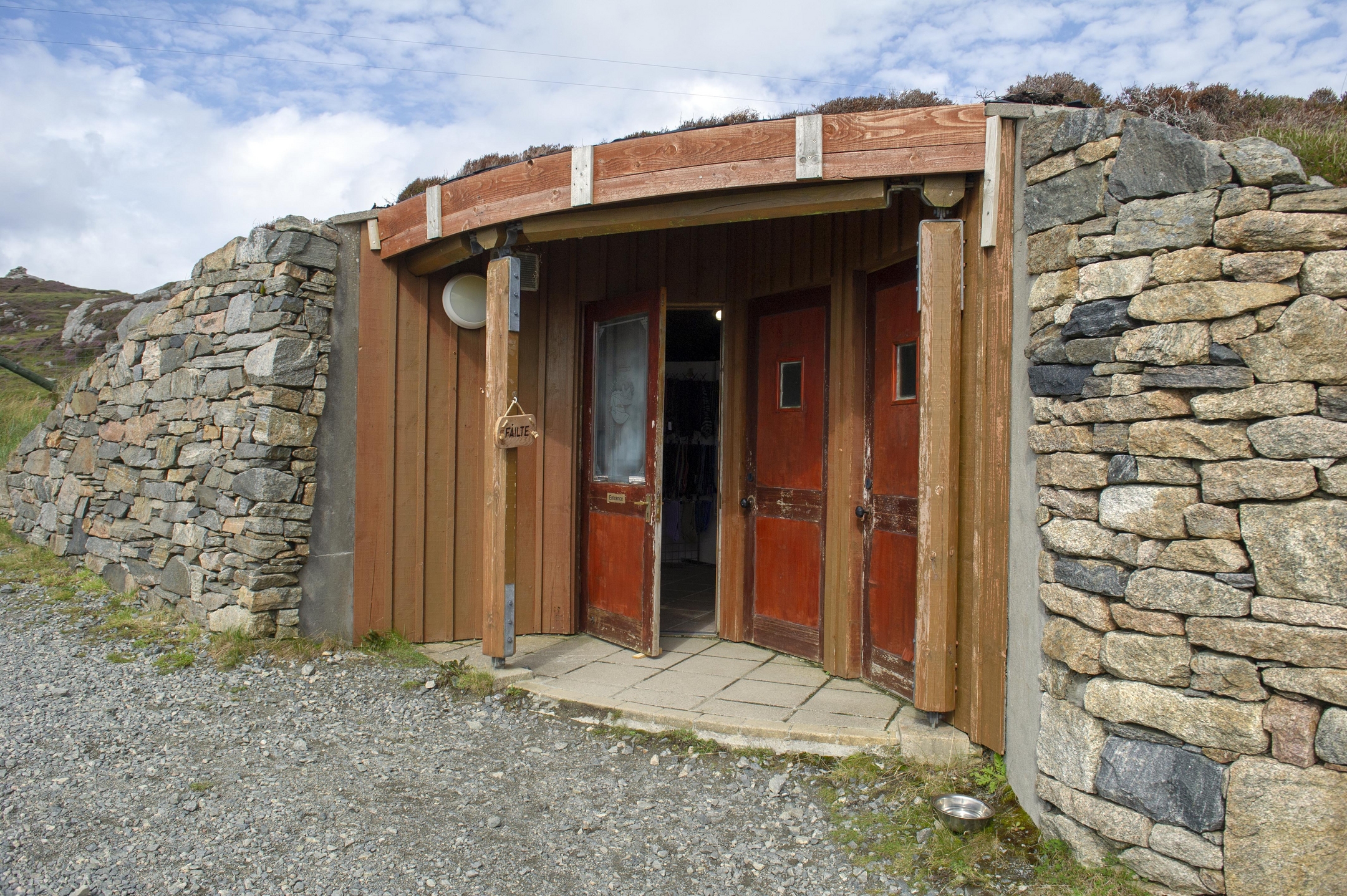 Wooden doorway in hillside with stone walls either side